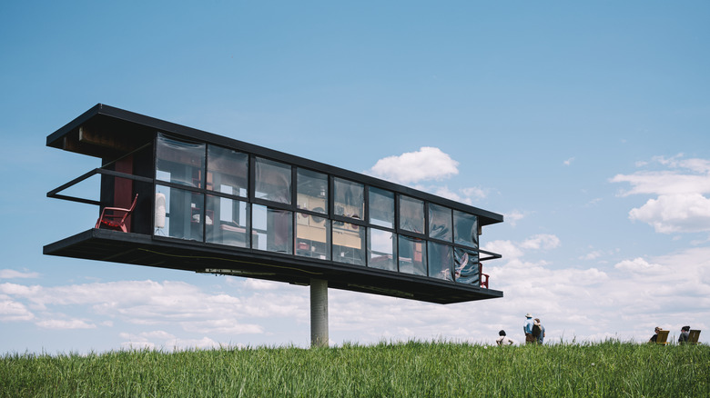 Elevated house sculpture in grassy outdoors at Art Omi