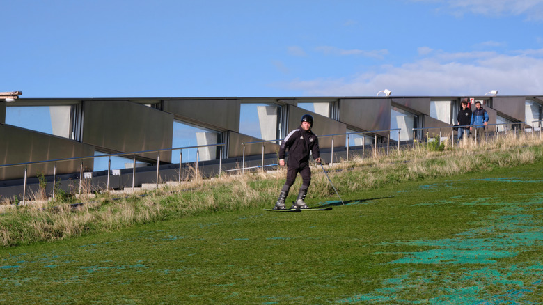 Person skiing on green artificial ski slope in copenhagen, Denmark