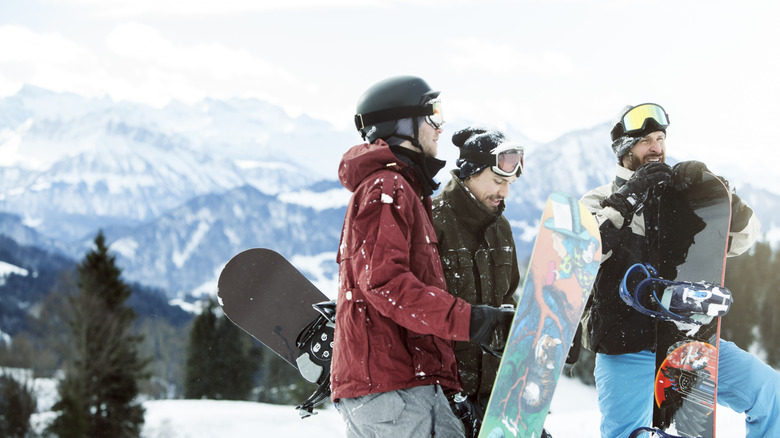 Three snowboarders standing in the snow