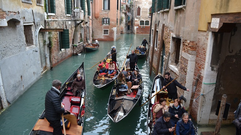 Multiple gondolas in a narrow Venice canal