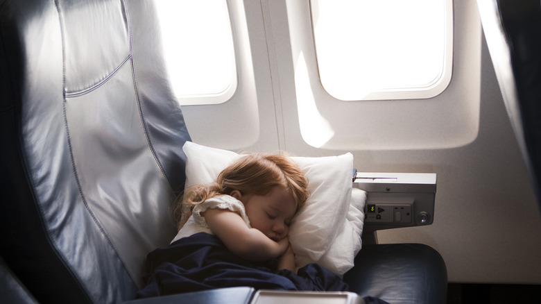 Child sleeping in plane seat