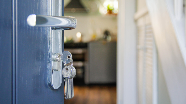 house front door open with keys in lock