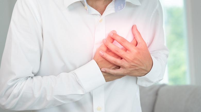 Man holding chest during attack