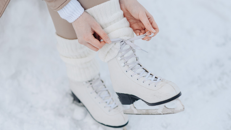 A person tying their ice skates