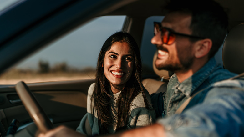 Smiling couple in a car on a road trip