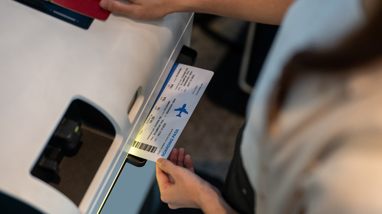 woman scanning paper boarding pass
