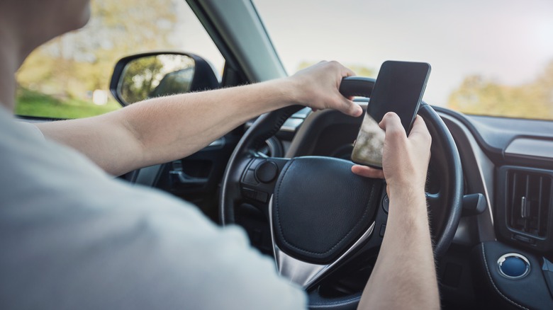 driver texting with hands on wheel