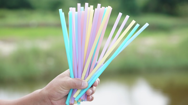 Someone holding lots of plastic straws