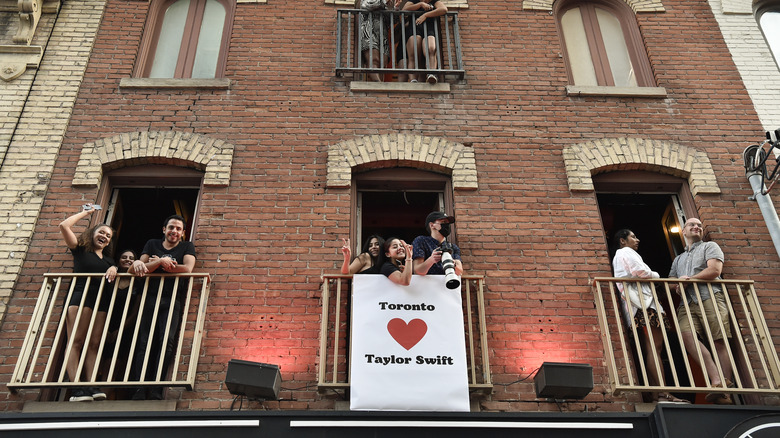 Toronto fans holding a sign that says "Toronto Heart Taylor Swift" from a balcony