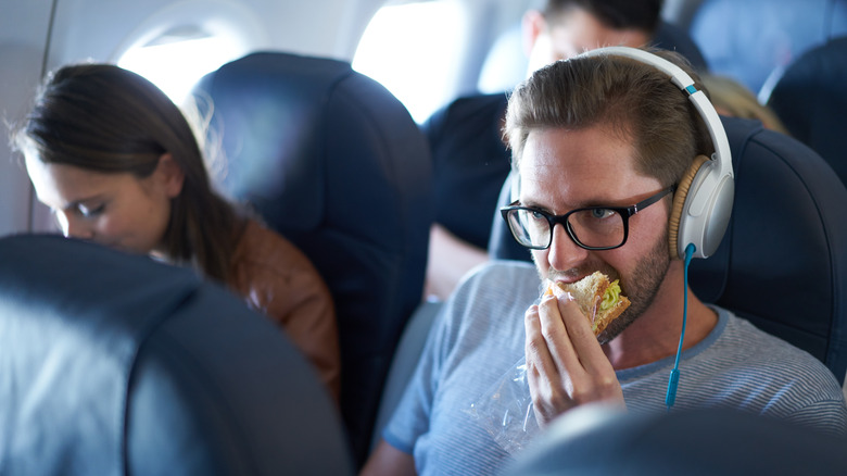 Airplane passenger eating a sandwich