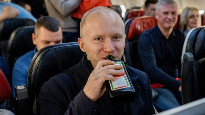 Man drinking alcohol on a plane