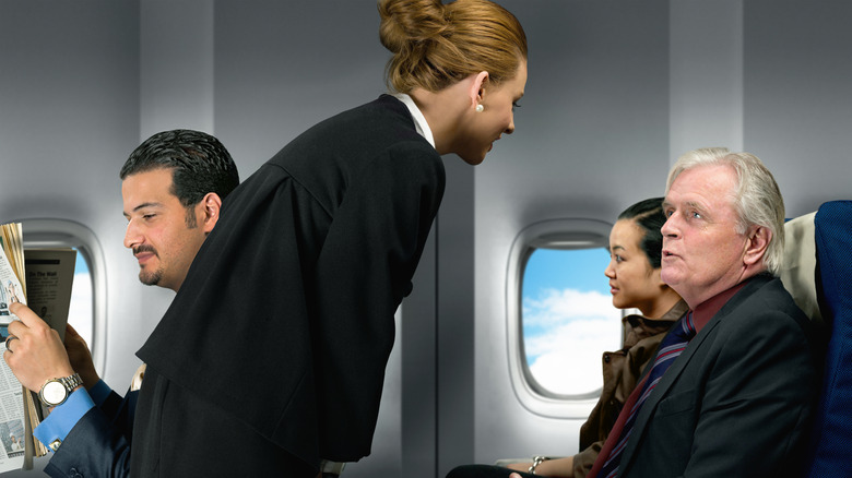 Flight attendant talking to a passeger