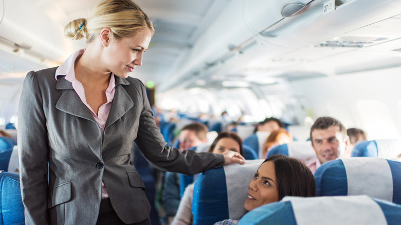 Flight attendant speaking with a passenger