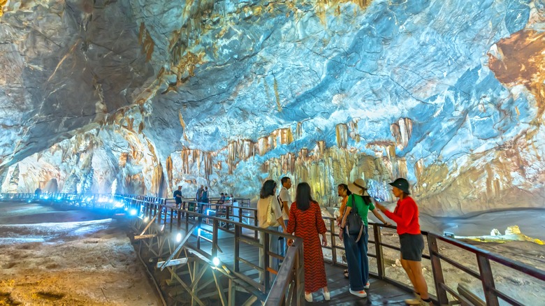 Tourists explore paradise cave