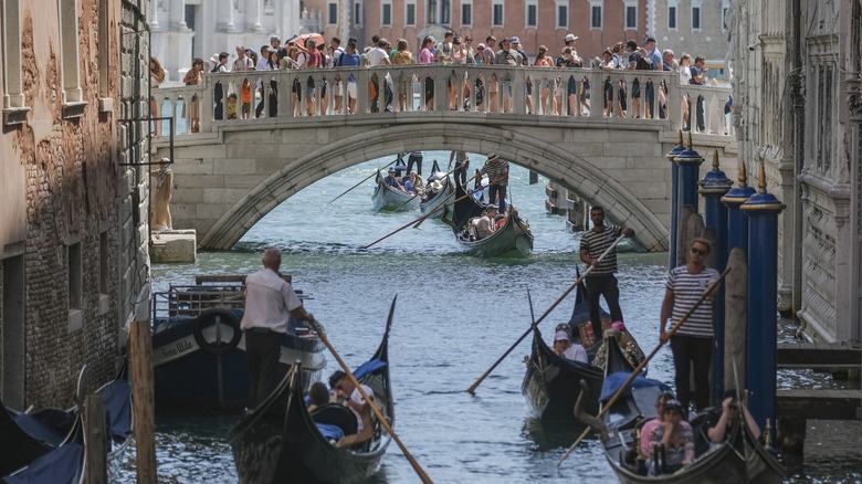 Gondola rides below canal in Venice