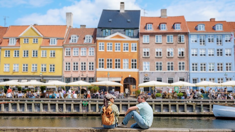 Man and woman sitting by the canal in Denmark