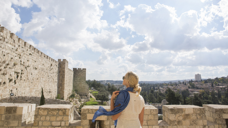 Woman in blue scarf looking at the Walls of Jerusalem