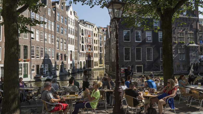 People sitting outside by the canal in the Netherlands