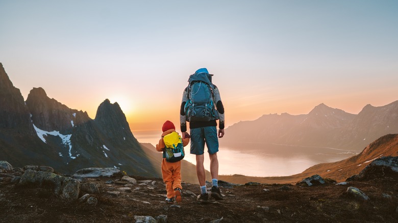 Man with a child trekking in the mountains of Norway