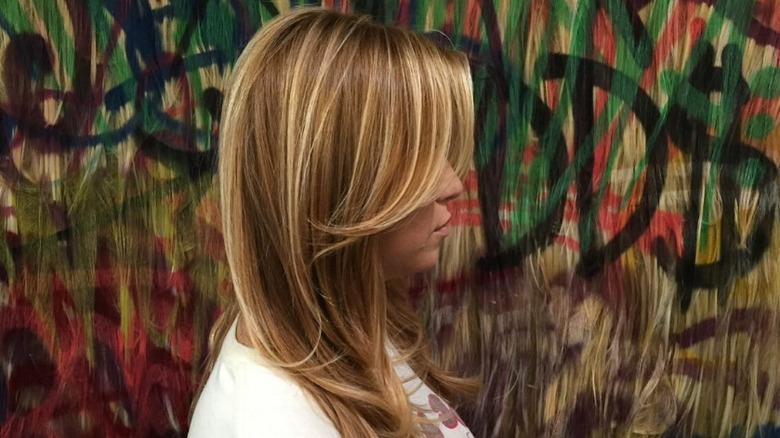 a haircut done at Salon Benjamin posed by graffiti wall