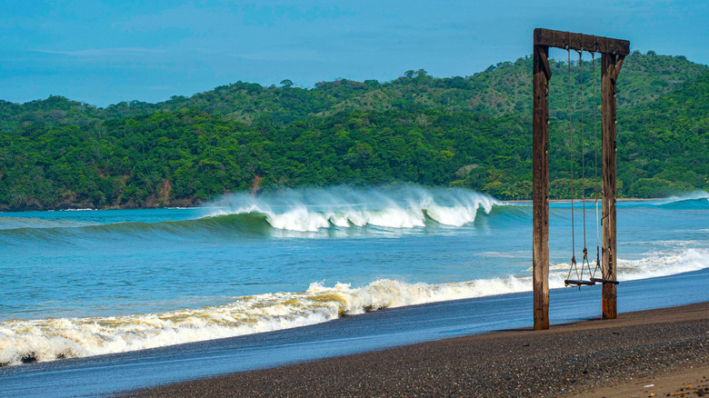 A waist-high waves crashes into the beach of Playa Venao on a sunny, off-shore day