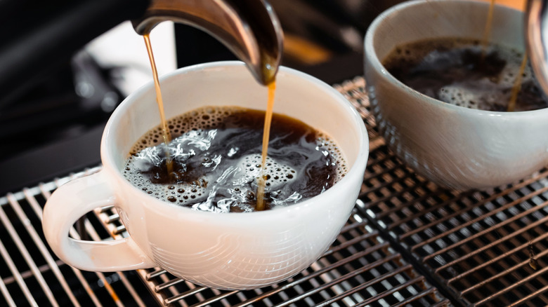 Machine pouring coffee or espresso into cup