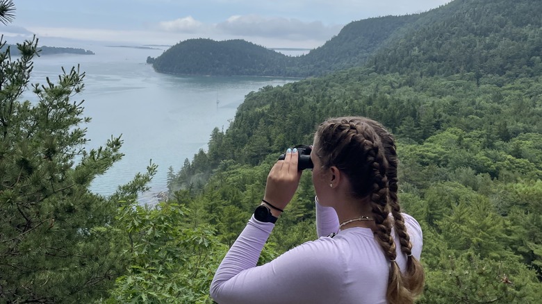 A birdwatcher with binoculars in Acadia National Park