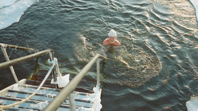 Man dipping into the cold water after the sauna in Finland for health benefits