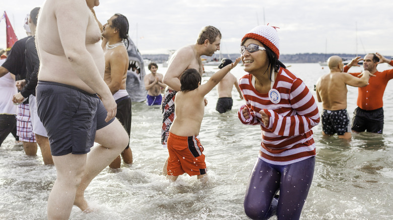 People rushing into the cold water of the English Bay in Vancouver, Canada for a yearly polar plunge