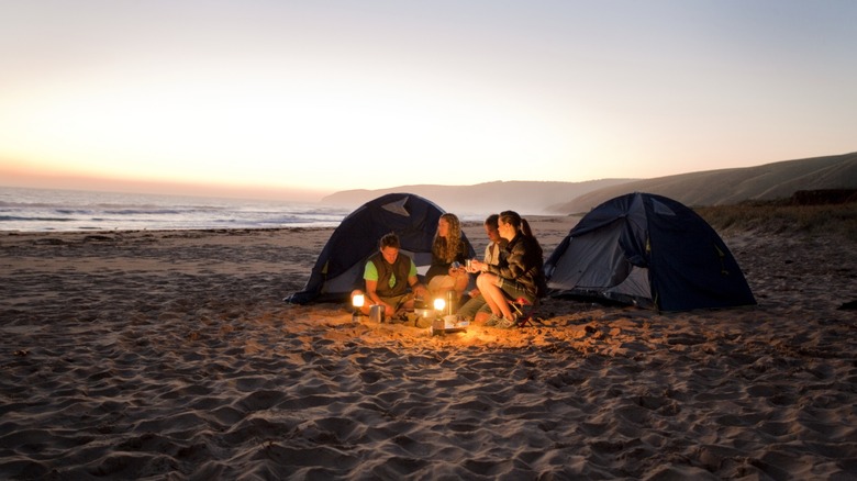 Camping on the beach with a fire.