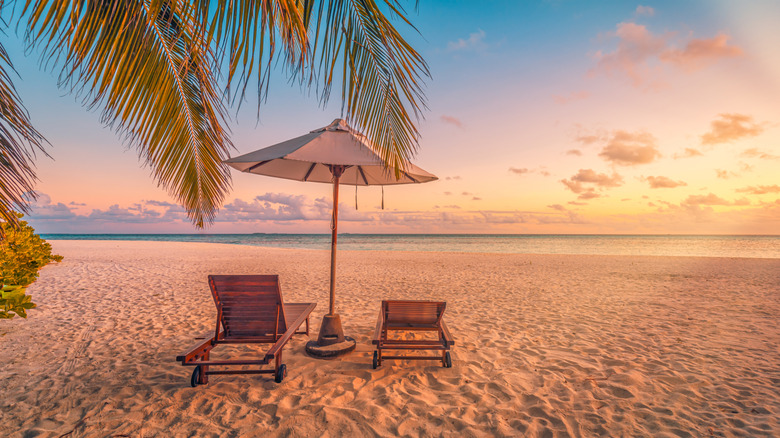 Two lounge chairs on Caribbean beach during sunset