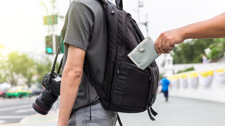 pickpocket stealing from backpack