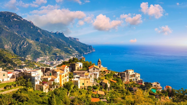 Hilltop town overlooking mountains and the sea.