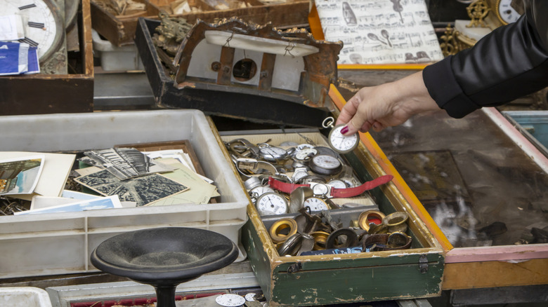 A female shopper picking up an antique pocket watch