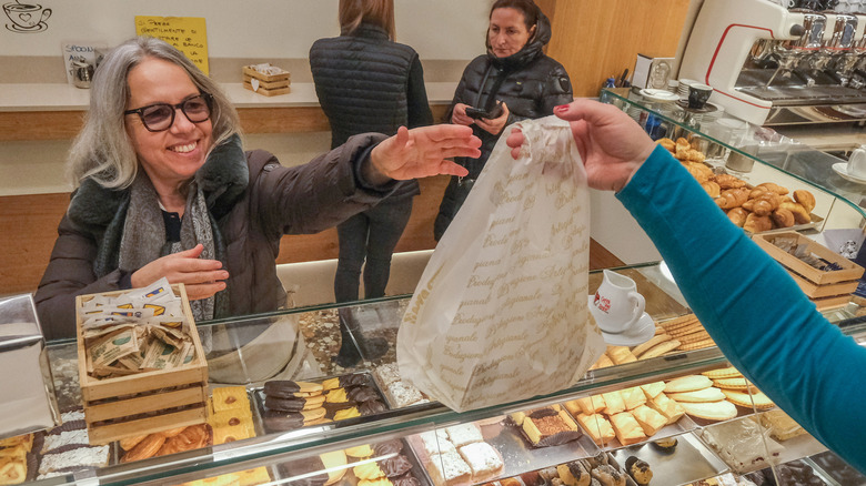 A woman buying cookies at a bakery in Italy