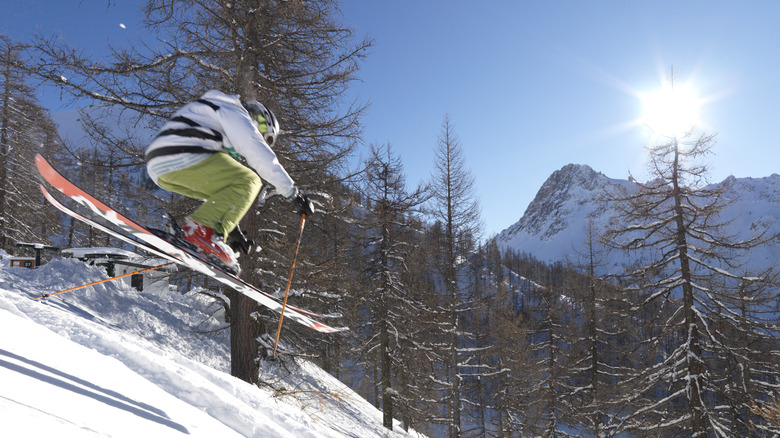 Skier jumping over fresh snow in Italian Alps