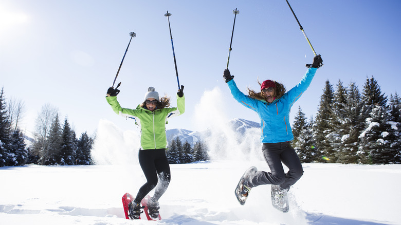 Two women jumping in snow