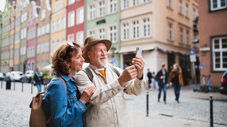 couple uses cellphone in european city