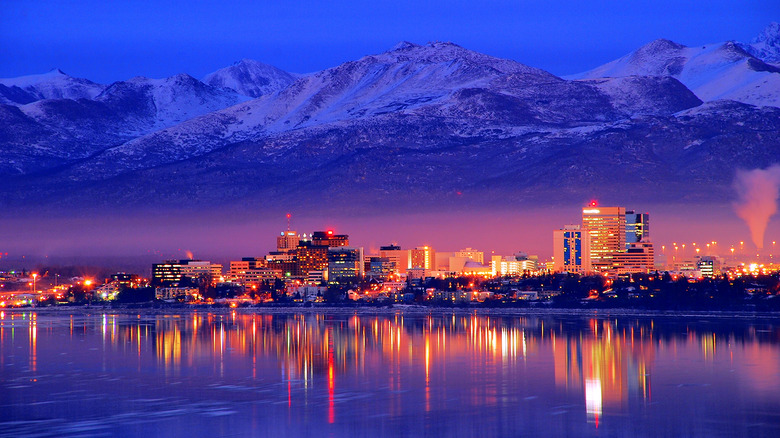 Bright Anchorage skyline against dark sky and mountains