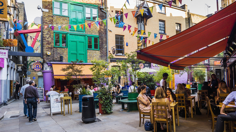 People eating on patios in a colorful London neighborhood