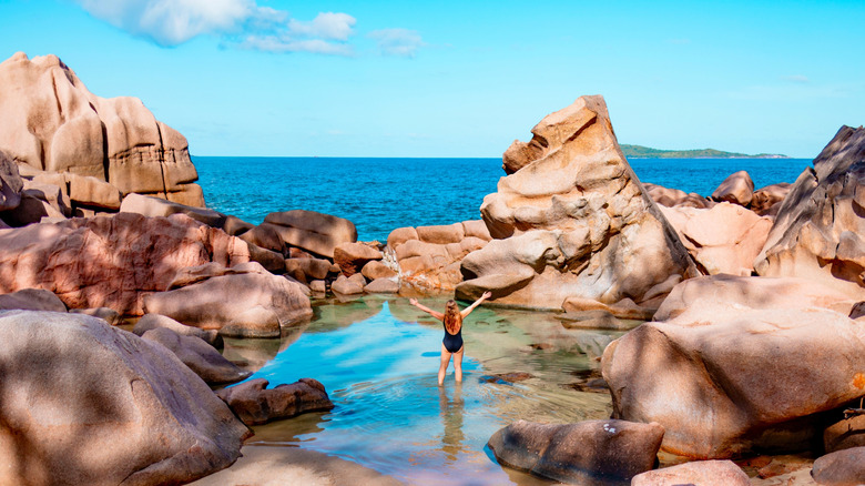 Woman standing in natural rock pool on La Digue island, Seychelles