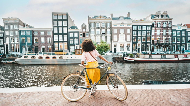 A woman stands with bike