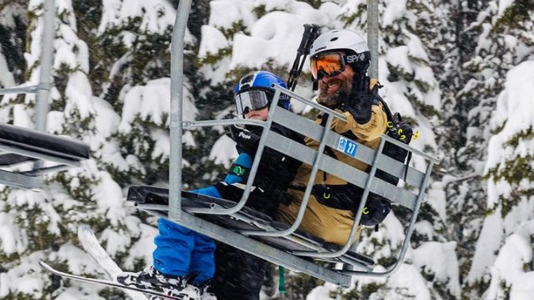 A father and son wave from a lift in Willamette Pass