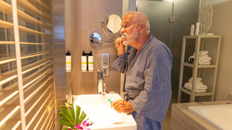 Man brushing teeth in hotel