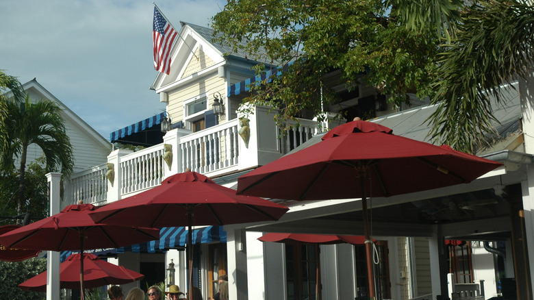 The exterior of La Te Da, including red umbrellas and a white balcony