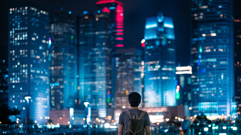 Man looking at a city at night