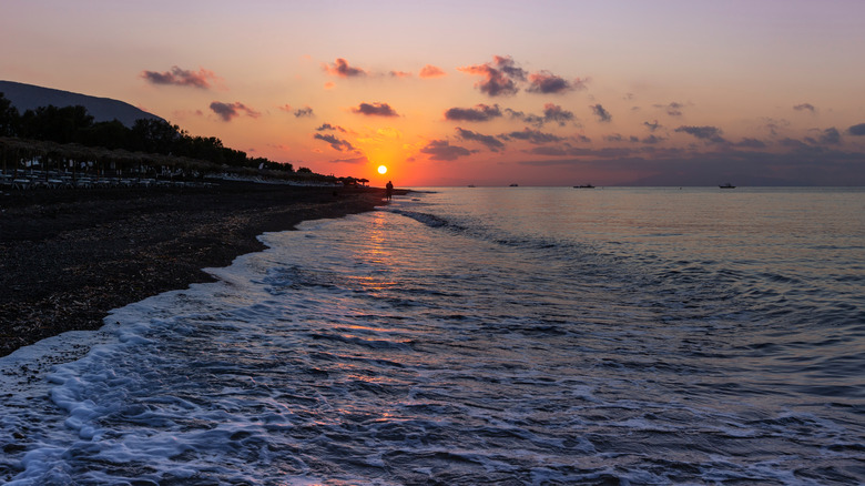 The black pebble beach of Perivolos at sunset.