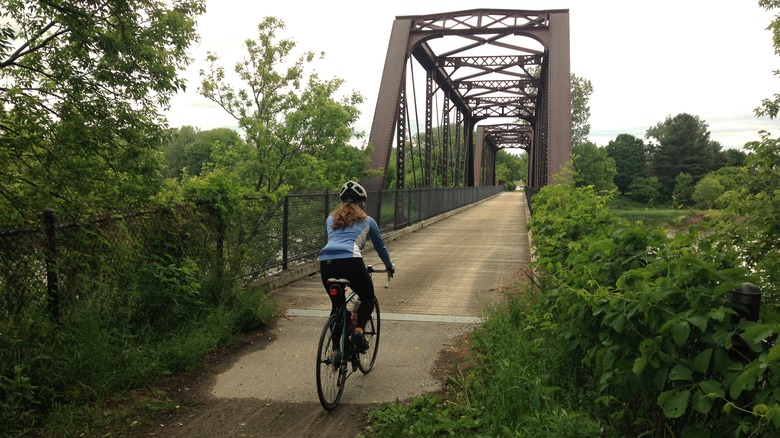 Woman biking across converted railway trestle