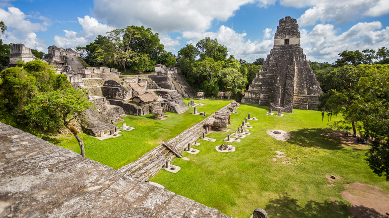 Ancient Mayan structures in Tikal, Guatemala, surrounded by green foliage