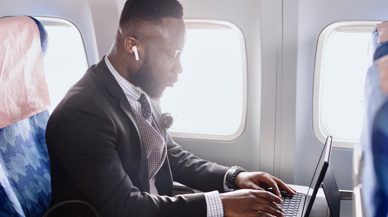 businessman typing window seat